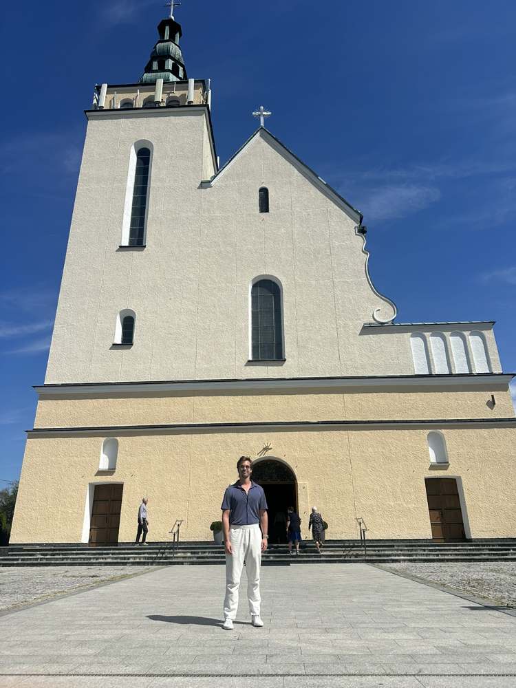 Zach in front of the Pysznica church, August 2026